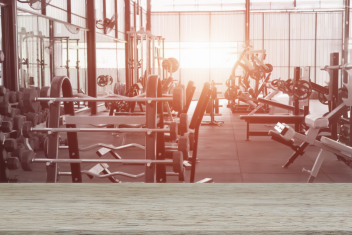 A low saturation shot of an empty gym.  The image is brightened by the sunrise peering through a window.